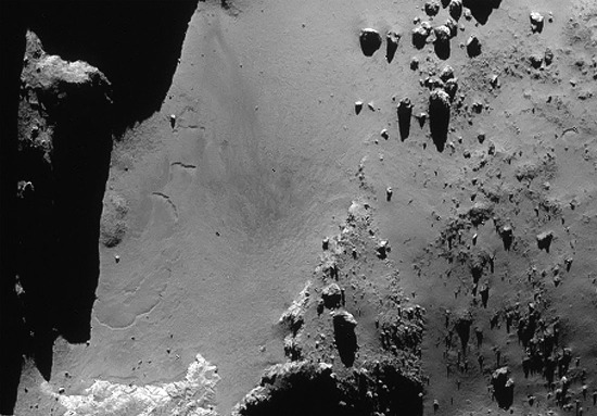 Zoom du du 9 décembre 2014 sur les quasi-sillons flexueux (à gauche) affectant la formation Hapi dans le cou au pied du lobe principal de la comète Chury