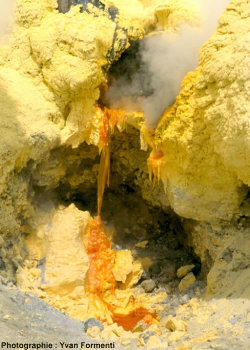Solidification du soufre liquide (orange vif) à la sortie d'une canalisation (presque complètement recouverte de soufre) au bord du cratère du Kawah Ijen (Est de Java, Indonésie)