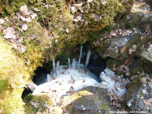 Stalactites et stalagmites de glace dans des cavités au fond d'un « trou à glace » de la cheire du Puy de Côme