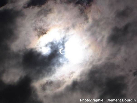 Éclipse partielle de Soleil photographiée sans filtre à travers un ciel nuageux le 3 octobre 2005