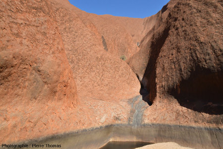 Trou d'eau dans le lit asséché du ruisseau d'une vallée sèche sur le flanc Sud-Est d'Uluru