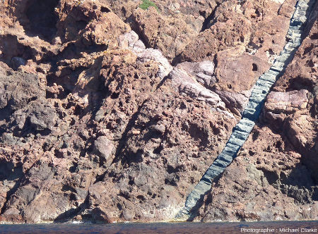 Filon de basalte (avec des prismes perpendiculaires aux bordures) recoupant des brèches rhyolitiques, réserve de Scandola (Corse)