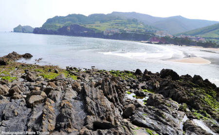 Vue de la baie de Bakio (Pays basque espagnol), prise depuis le pied des falaises des figures 1 à 7, avec au fond l'encaissant oriental du diapir et au premier plan l'encaissant occidental