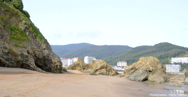 Vue globale sur un affleurement en place de basalte (à gauche) et de blocs éboulés sur la plage, Bakio (Pays basque espagnol)