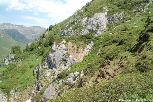 Vue générale sur une passée bréchique rousse-orangée au sein des carbonates, ravin de Paumères (Ariège)