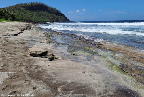 Détail du sable de la plage de Grande Anse (La Réunion), vue en direction du Sud, avec le Piton de Grande Anse en fond