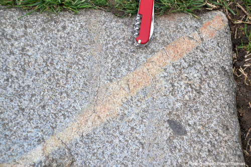 Zoom sur une dalle de granite avec un filon décalant une bande grise, voie romaine de Fourvière (Lyon, Rhône)