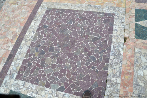 Vue d'un motif rectangulaire composé de très nombreuses mini-dalles de ce que le panneau explicatif appelle « porphyre rouge (Égypte) », sur la scène de l'Odéon, petit théâtre romain de Fourvière (Lyon, Rhône)