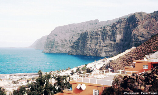 Vue éloignée sur les Falaises des Géants, leurs alternances horizontales, et leurs dykes, avec la ville de Los Gigantes au premier plan, Tenerife (Canaries)