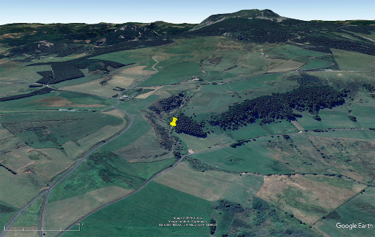 Vue aérienne vers le Sud de la petite vallée entaillant la bordure du maar de Chaudeyrolles (Haute-Loire) et les coulées qu'elle recoupe