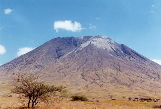 Photographie du volcan Oldoinyo Lengaï, prise depuis le sol de la vallée du rift Est-africain