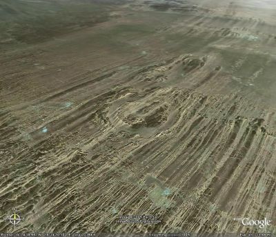 Un cratère de météorite (au centre) recoupé par des yardangs (figures d'érosion éolienne) dans le Sahara (Tchad)