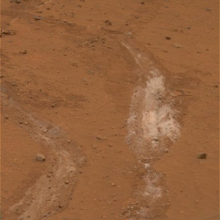 Mars : tranchée creusée (volontairement) par une des roues de Spirit laissant apparaître une substance blanche sous la couche superficielle de poussières rougeâtres