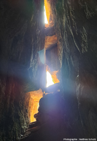 Entrée Est du Saint-Trou depuis l'intérieur, cavité formée par l'érosion, probablement en reprenant une zone fragilisée par un accident tectonique ou une diaclase, sur la face Nord-Est du rocher de Roquebrune-sur-Argens (Var)