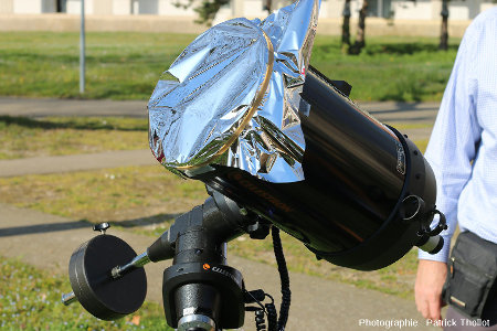 Filtre AstrosolarTM fixé à l'aide d'un élastique (avec addition de ruban adhésif pour limiter la prise au vent) devant la lentille frontale d'un télescope Schmidt-Cassegrain Celestron C8 de 20 cm d'ouverture